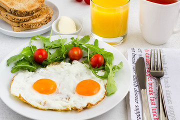 Fried egg with vegetables, fresh orange juice, a cup of tea and toast. 