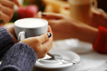 Woman holding cup of coffee in cafe