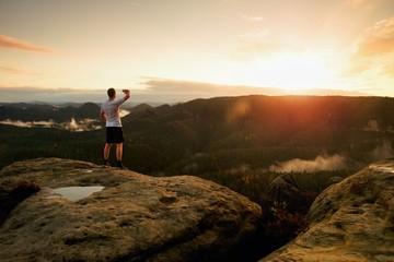 Obraz premium Runner man in his target with hand in the air. Sweaty man in black pants and white sweaty t-shirt,