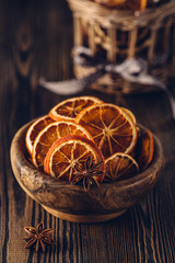Anise and dried oranges in bowl on a wooden table. Shallow dof.