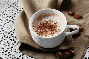 Cup of hot cacao with sweets on cotton serviette