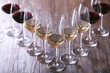 Wineglasses with white, red and pink wine on wooden table close-up