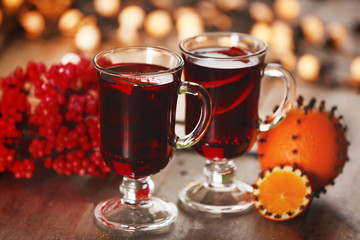 Mulled wine with spices and Christmas tree on wooden background