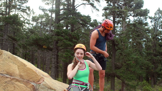 Smiling couple preparing themselves to rock climb