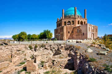 Ruins of stone citadel and historical mausoleum Dome of Soltaniyeh background. The structure, erected in 1312 AD in Iran. - obrazy, fototapety, plakaty