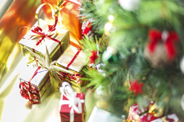Christmas decoration with gifts and present boxes under a pine tree.
Golden harmony, warm atmosphere.