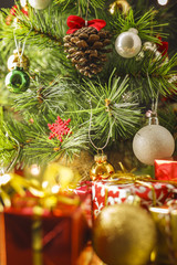 Christmas decoration with gifts and present boxes under a pine tree.
Golden harmony, warm atmosphere.