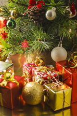 Christmas decoration with gifts and present boxes under a pine tree.
Golden harmony, warm atmosphere.