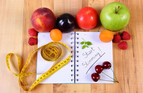 Fruits, vegetables and centimeter with notebook, slimming and healthy food