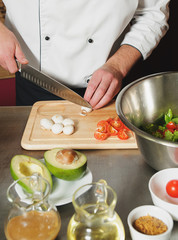 chef cutting mushrooms on table