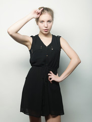 Fototapeta premium young fashion blond woman in black dress posing in studio 