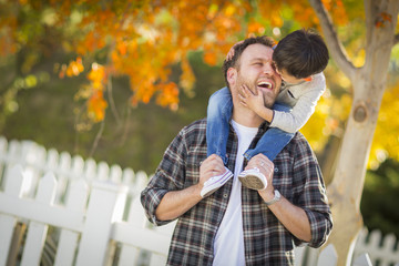 Mixed Race Boy Riding Piggyback on Shoulders of Caucasian Father