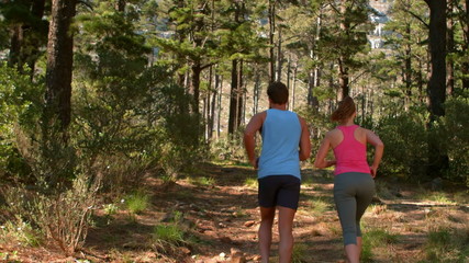 Back view of couple couple jogging - Powered by Adobe