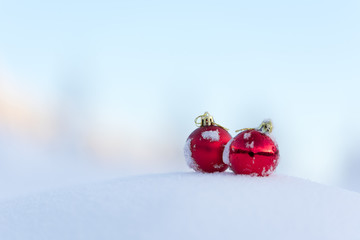 red christmas balls in fresh snow