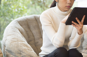 Women are looking at the tablet in a cafe