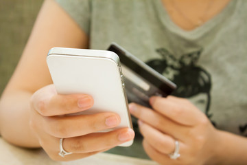 female holding smartphone and credit card, shopping online conce