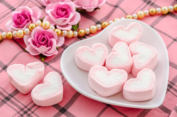 Obraz na płótnie Canvas sweet heart shape of pink marshmallows with flower.