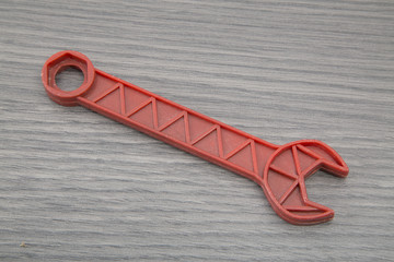 Llave inglesa de juguete sobre fondo de madera.