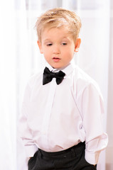 blond boy in white shirt with black bow tie