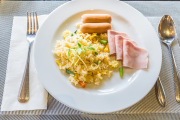 Fried rice with sausage, hams and egg on wooden table. TOP VIEW