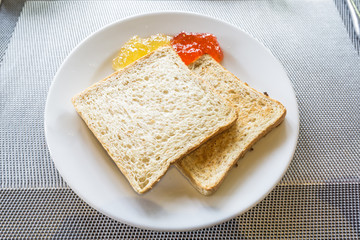 Bread, butter and jam, orange marmalade, strawberry and berry.