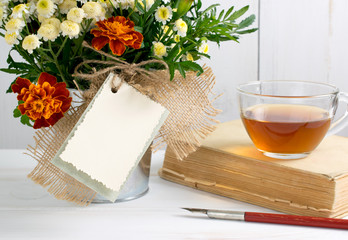 Tagetes flower bouquet with decorative greeting card and old boo