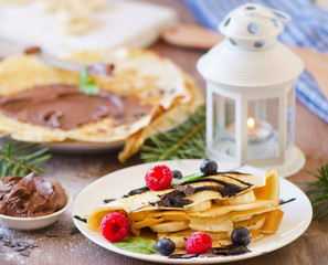 Christmas breakfast. Crepes with chocolate cream and fresh berri