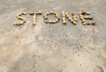 Fototapeta na wymiar Closeup text by stone on old concrete floor texture background in vintage tone