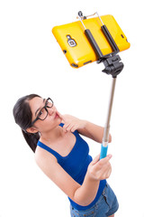 Happy woman taking picture with smartphone selfie stick