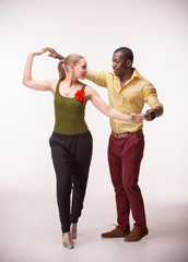 Young couple dances Caribbean Salsa, studio shot