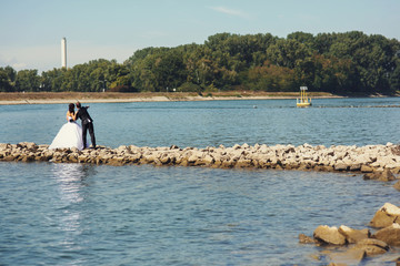 Fototapeta na wymiar Happy couple bride and groom on a rocky shore river romantic lan