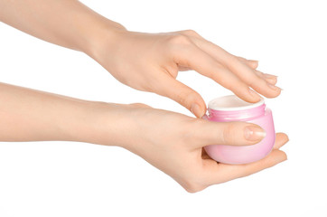 Body care and health topic: a woman's hand holding a pink jar of cream isolated on white background in studio
