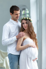 Cheerful young couple  dressed in white standing at home