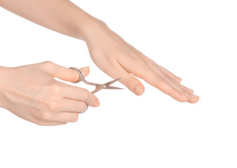 Health and personal care: female hand holding scissors for manicure isolated on white background in studio