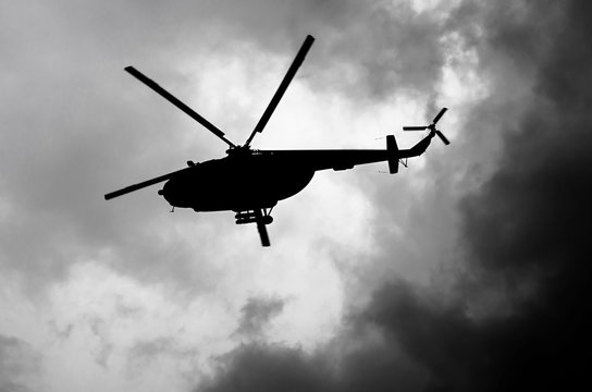 silhouette of a helicopter in the clouds, black and white