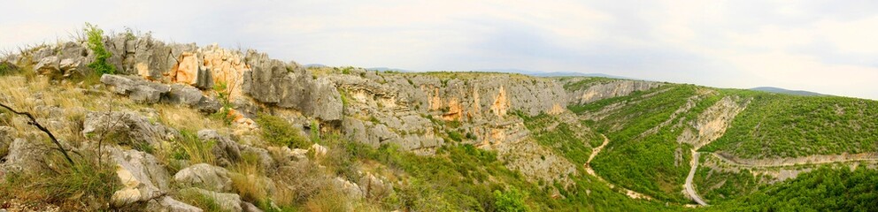 Fototapeta na wymiar Rocky cliffs and road in Čikola canyon in Dalmatia, Croatia