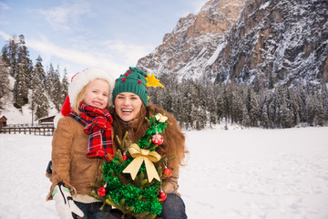 Smiling mother and child with Christmas tree into the mountains