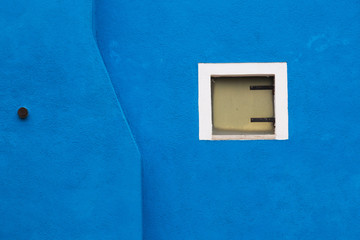 Blue wall of the house with a large window, Burano, Venice