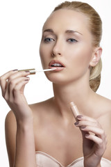 beautiful young woman applying lip gloss