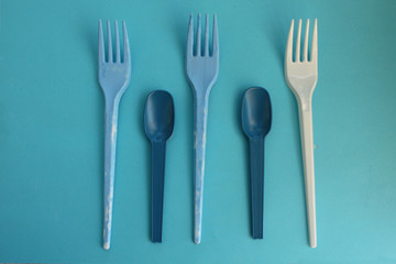 Blue and white fork and spoon on blue background - party time concept