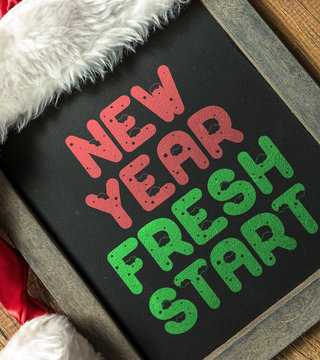New Year Fresh Start written on blackboard with santa hat