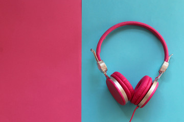 Pink headphones on colorful background