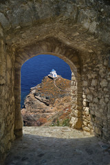 Fototapeta na wymiar Small church through old castle on Santorini island, Greece