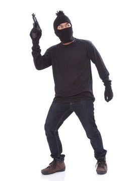 Burglar in a mask with a gun on a white background