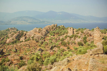Fototapeta na wymiar Landscape with ruins of Byzantine town over the lake, nature reserve of Turkey with olive trees and mountains around