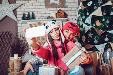 Couple in love in Christmas decorations make the selfie