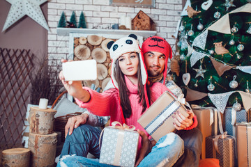 Couple in love in Christmas decorations make the selfie