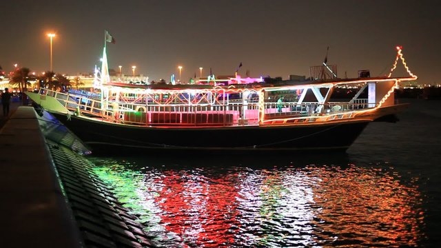 Traditional arabian dhow boat at the corniche of Doha city at night, Qatar