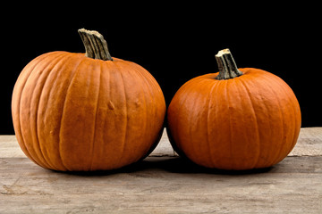 Closeup shot of beaded pumpkins on wooden board on black
