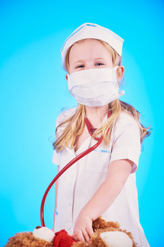 Little girl dressed as a doctor, a nurse with a stethoscope, exa
